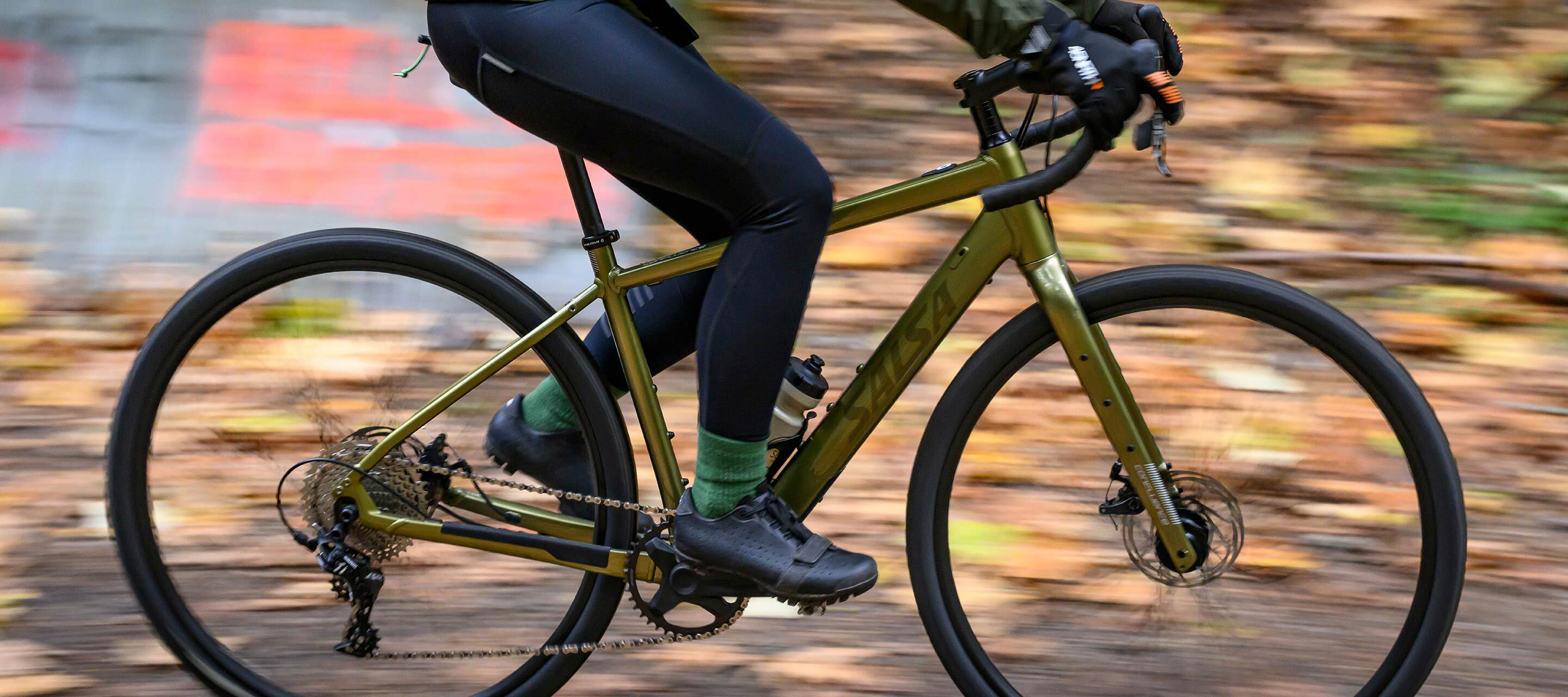 Cyclist riding Salsa Confluence Drop Bar Ebike on gravel road focus on bike