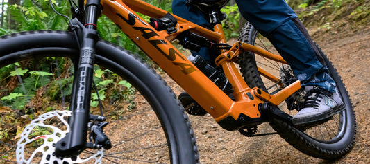 Cyclist riding Salsa Moraine eMTB on trail focus on bike