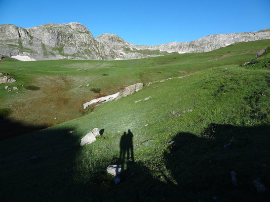 Clear blue sky with grass valley and mountain view, Kurt and Kaitlyn’s shadow in foreground