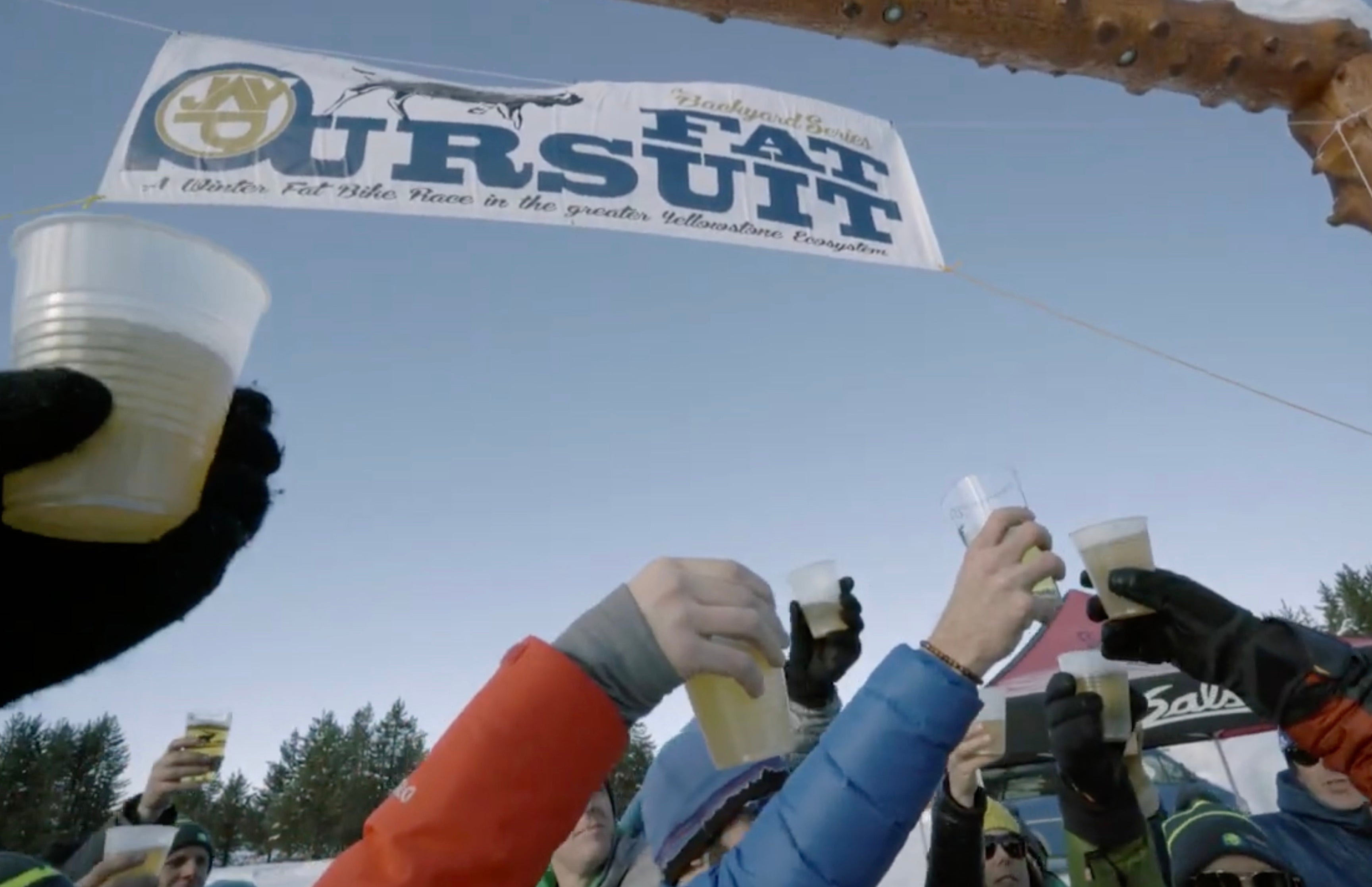 A group of cyclists cheers with the drinks at the finish line of the Fat Pursuit.