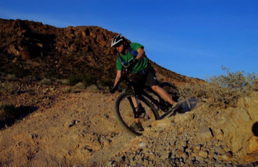 Mountain biker descends down a dirt trail.