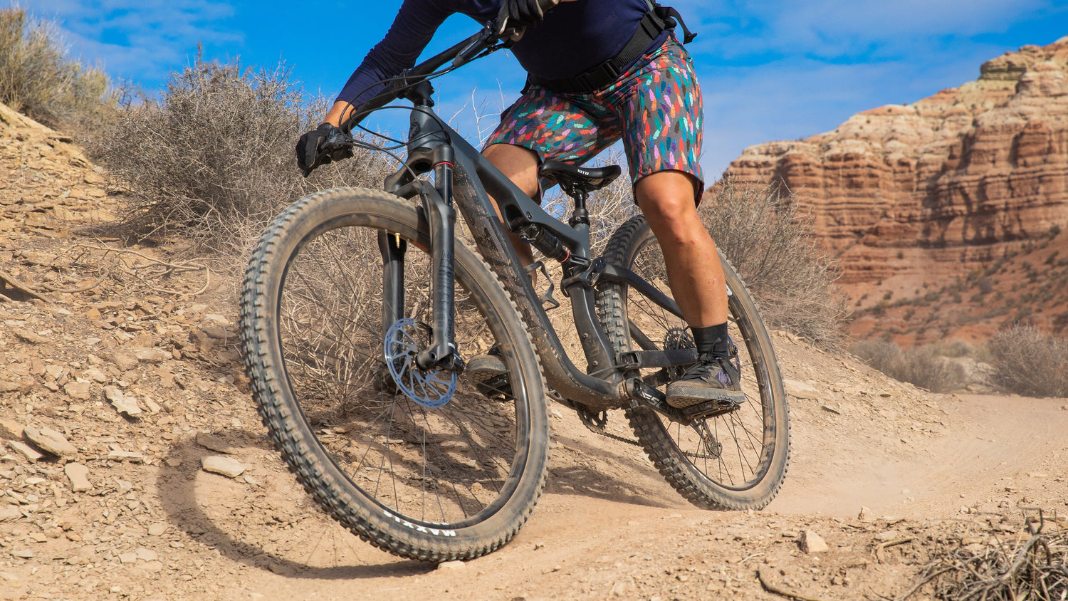 Mountain biker rides a Salsa Horsethief full suspension bike on a dirt trail.