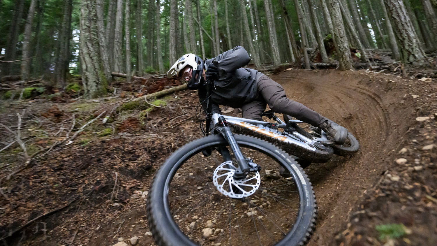 Mountain bike rides around a tight curve on a dirt trail on their Salsa Notch ebike.