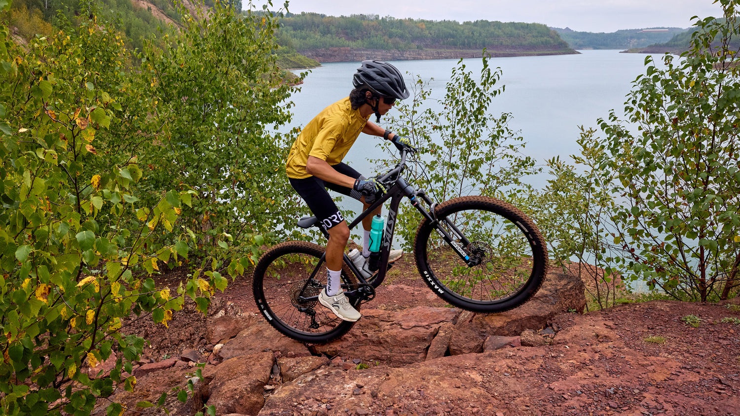 Cyclist rides a Salsa Rangefinder hardtail mountain bike over rocky terrain.