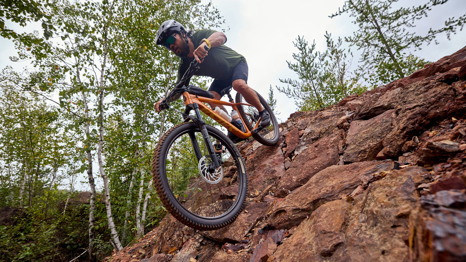 Mountain biker aggressively descends down rocky terrain on a Salsa Timberjack hardtail bike.