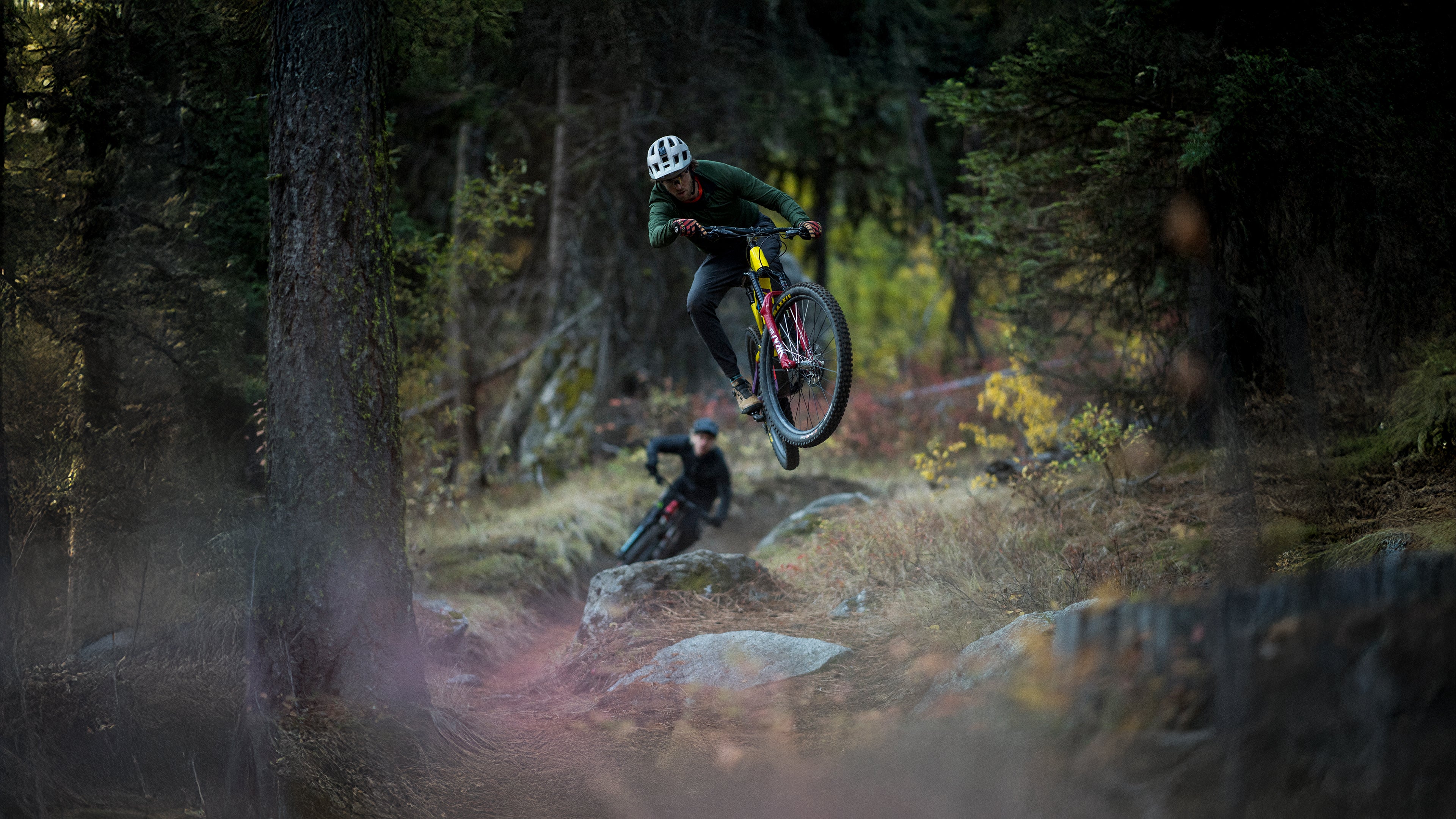 Mountain biker gets air while riding a full suspension Salsa bike on a rocky trail.